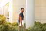 man holding laptop walking towards building