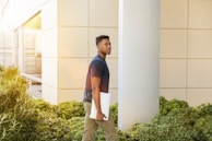 man holding laptop walking towards building