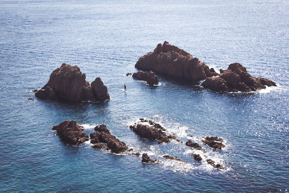 bird's eye view photo of rock formation surrounded by body of water