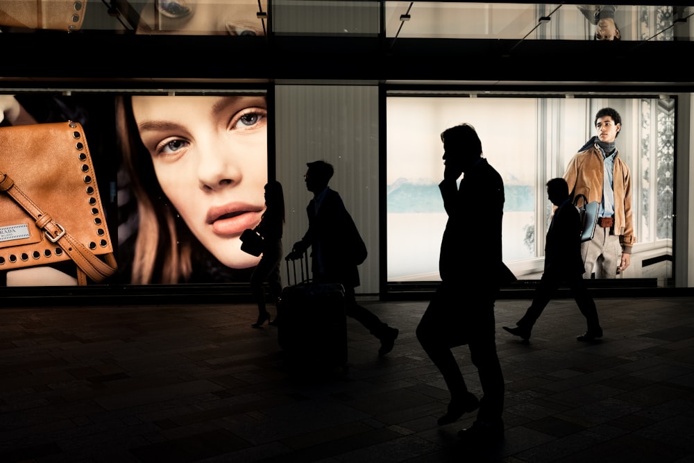 silhoutte of three persons near billboard