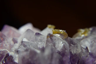 Close-up of a polished amethyst gemstone glowing softly against a dark, velvety background.