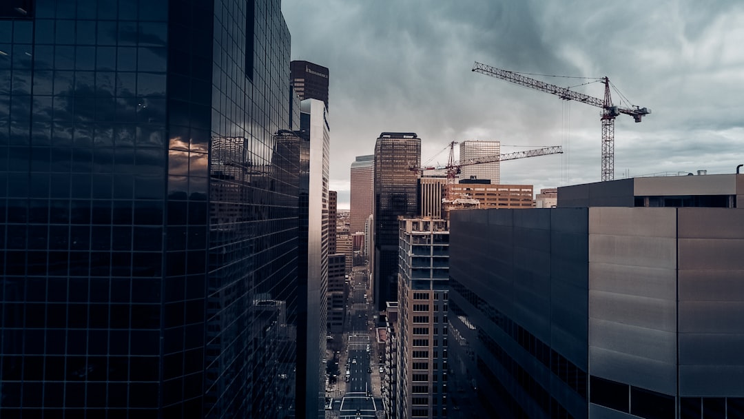 road surrounded by black high-rise buildings, Cranes in Denver