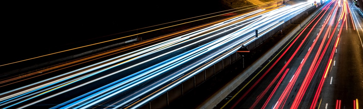 time-lapse photography of cars passing through the road during night time