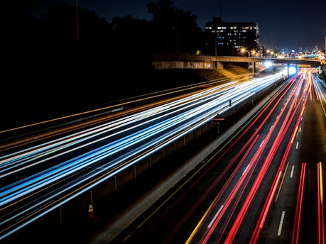 time-lapse photography of cars passing through the road during night time