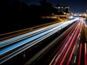 time-lapse photography of cars passing through the road during night time