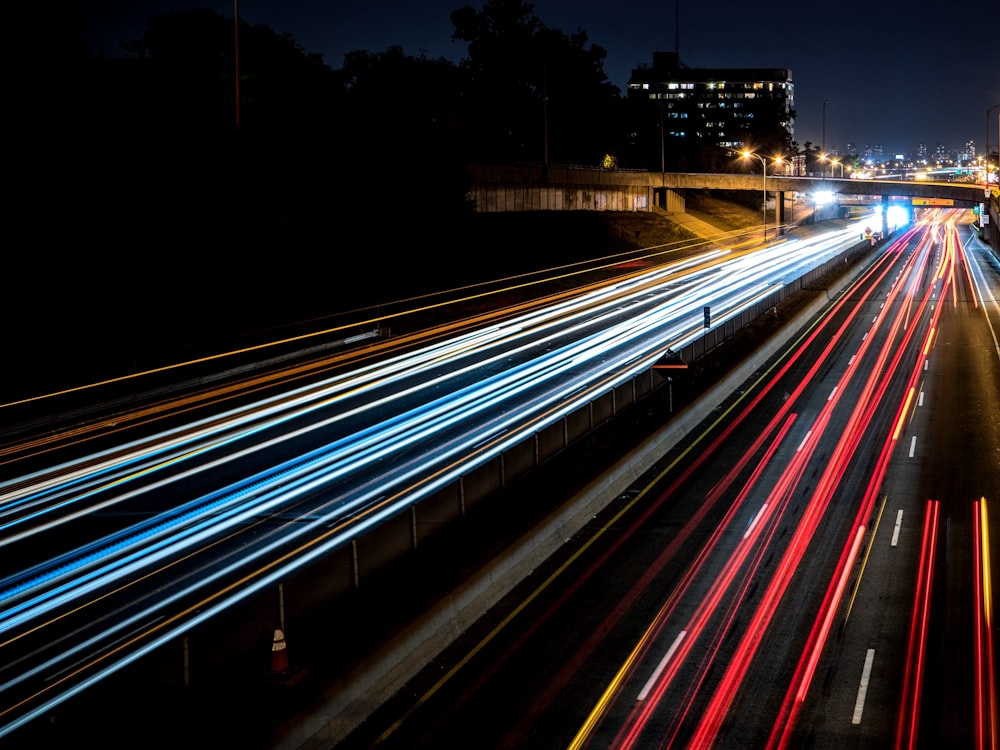 Photographie en accéléré de voitures traversant la route pendant la nuit
