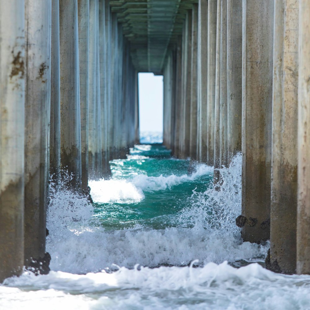 Onde d'acqua sotto il ponte di cemento durante il giorno