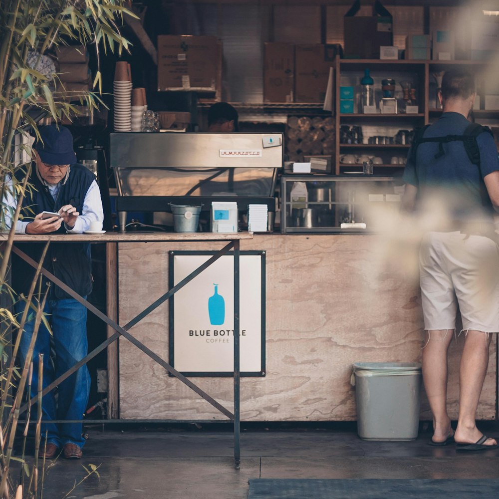 Mann lehnt sich an Tisch vor Café