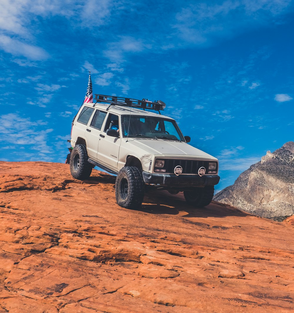 gray Jeep vehicle in rock terrain during daytime