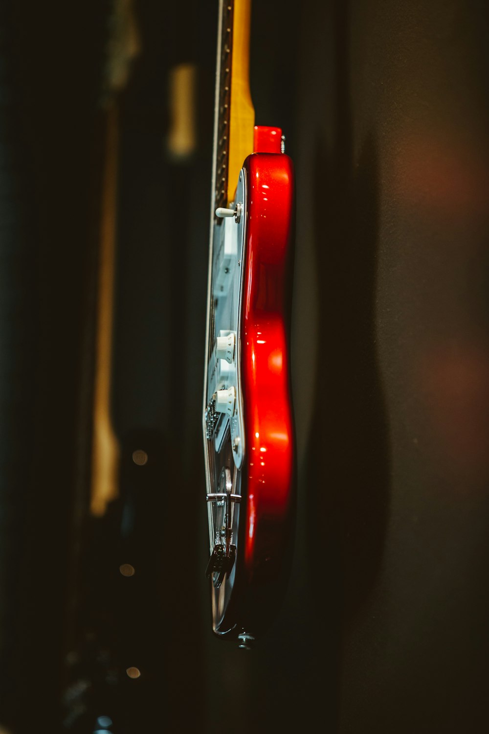 white and red stratocaster electric guitar hanging on wall