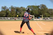 Action shot of a player wearing a Vipers helmet and face guard mid-pitch on a sunny softball diamond.
