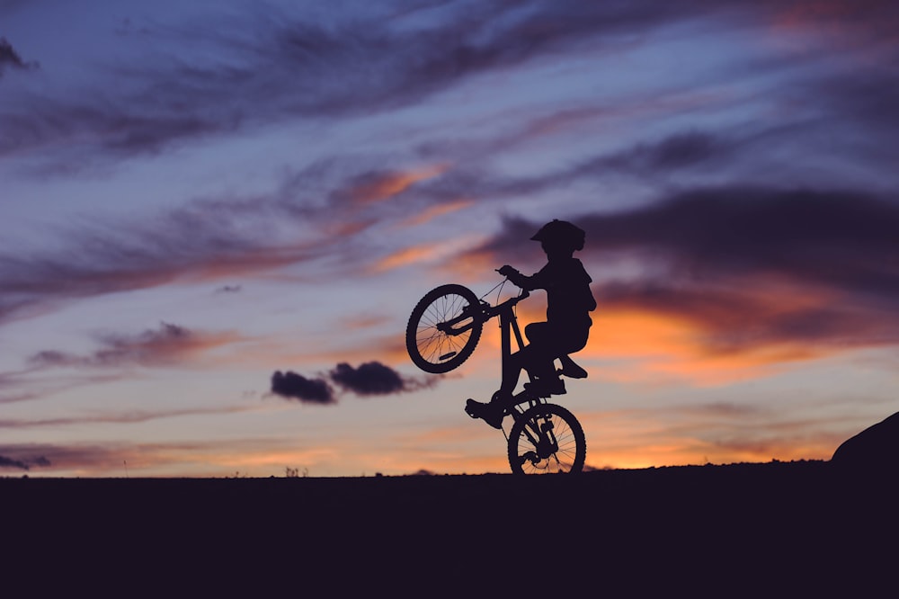 silhouette of child riding on bike