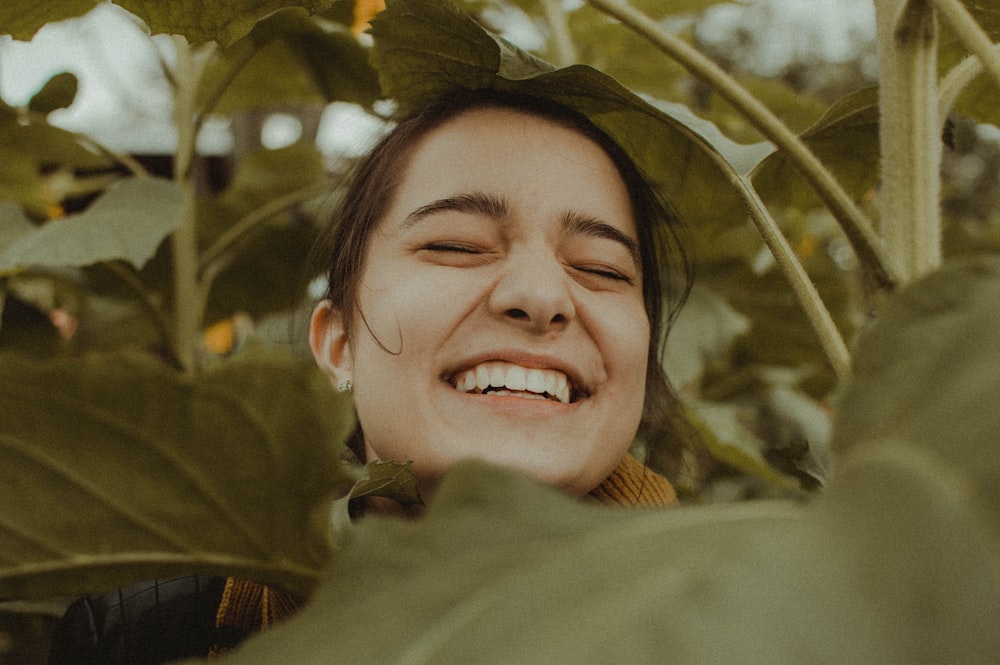 植物の間で微笑む女性