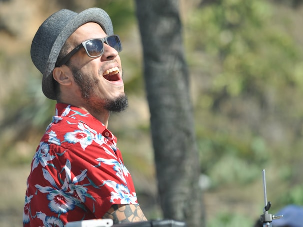 A cheerful user laughing on a video call, wearing a Mindwear shirt that reads a clever, camera-friendly phrase.