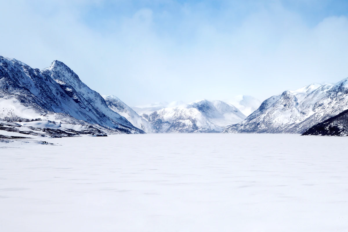 Snow covered Norwegian mountains under a clear winter sky