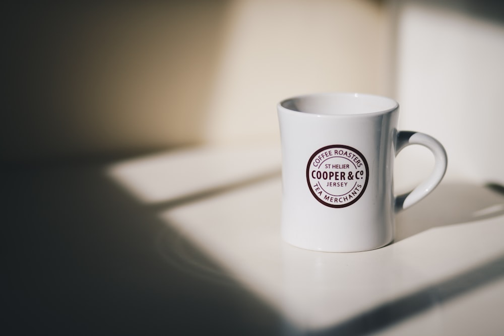 selective focus photo of white mug on white surrface