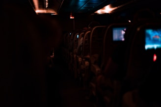 A sleek airplane cabin showcasing seat-back screens displaying vibrant advertisements.