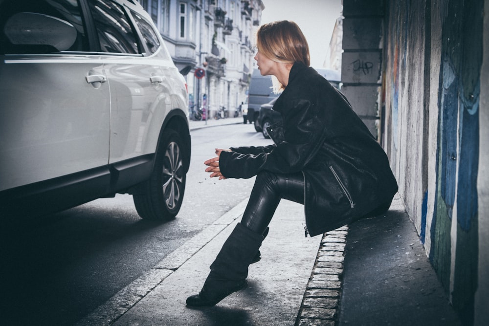 femme assise sur le trottoir en béton gris