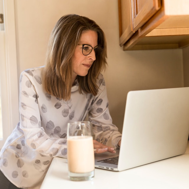 woman using her MacBook Pro inside white room