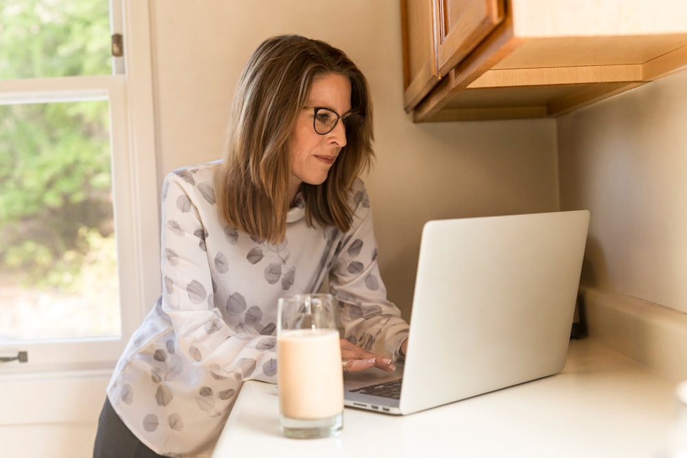 mujer usando su MacBook Pro dentro de una habitación blanca