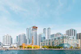 body of water near high-rise buildings under blue sky