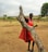 Close-up of a vibrant Maasai warrior sharing stories with visitors under acacia trees.