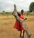 Close-up of a vibrant Maasai warrior sharing stories with visitors under acacia trees.
