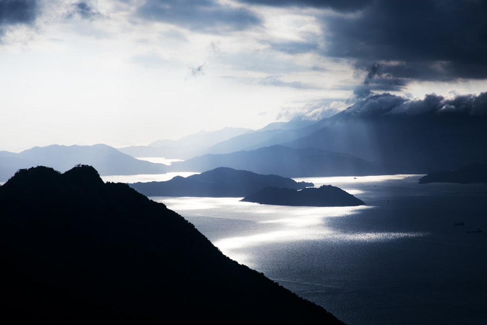 silhouette of mountains surrounded by body of water