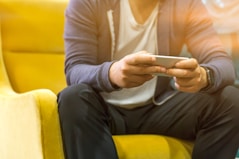 person holding smartphone sitting on couch