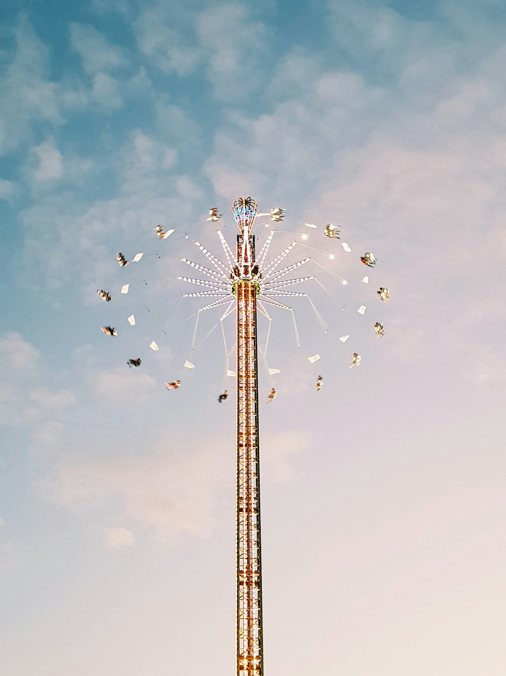 multicolored amusement park ride under white clouds during daytime