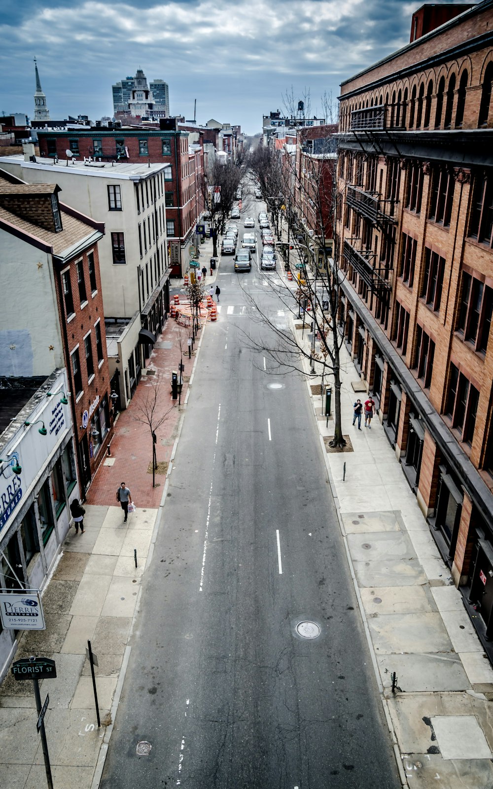 建物と建物の間にあるコンクリートの通りに車両が並んでいる鳥瞰写真