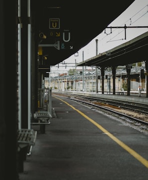 empty benches on train station beside railway at daytime