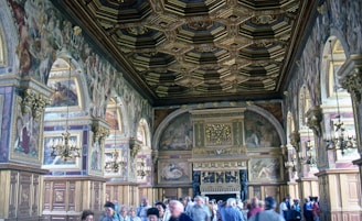 Photographer capturing the vibrant opening ceremony inside a grand hall adorned with royal blue and gold decorations.