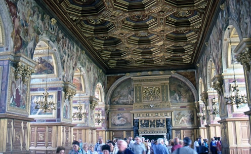 Photographer capturing the vibrant opening ceremony inside a grand hall adorned with royal blue and gold decorations.