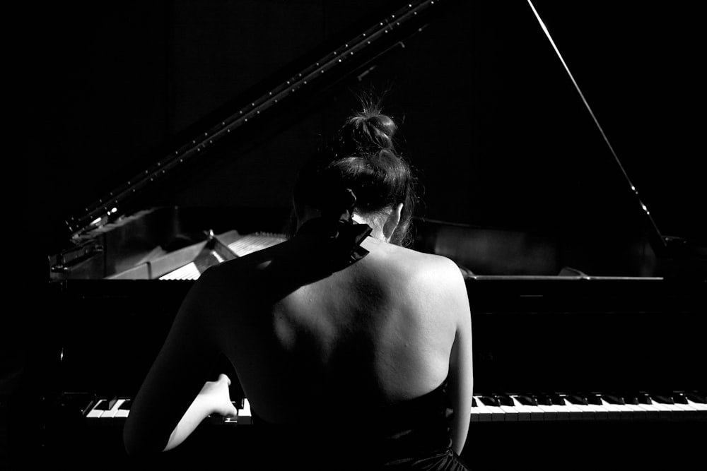 Fotografía de enfoque selectivo de mujer tocando piano de cola