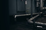 gray pipes mounted on concrete wall arrangement