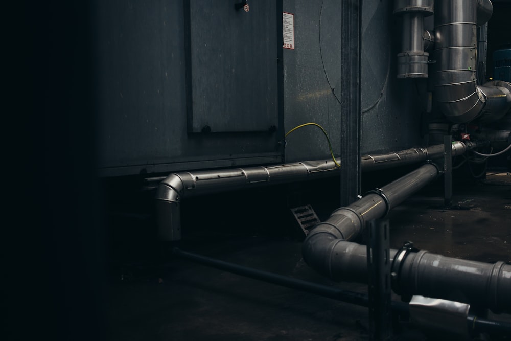 gray pipes mounted on concrete wall arrangement