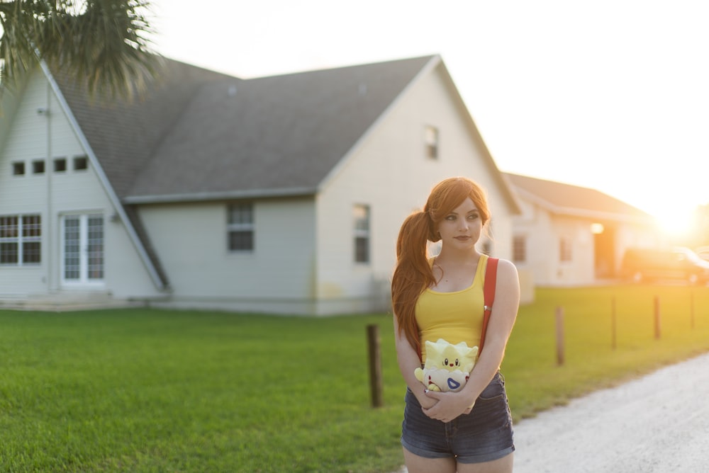 woman standing near white house during daytime