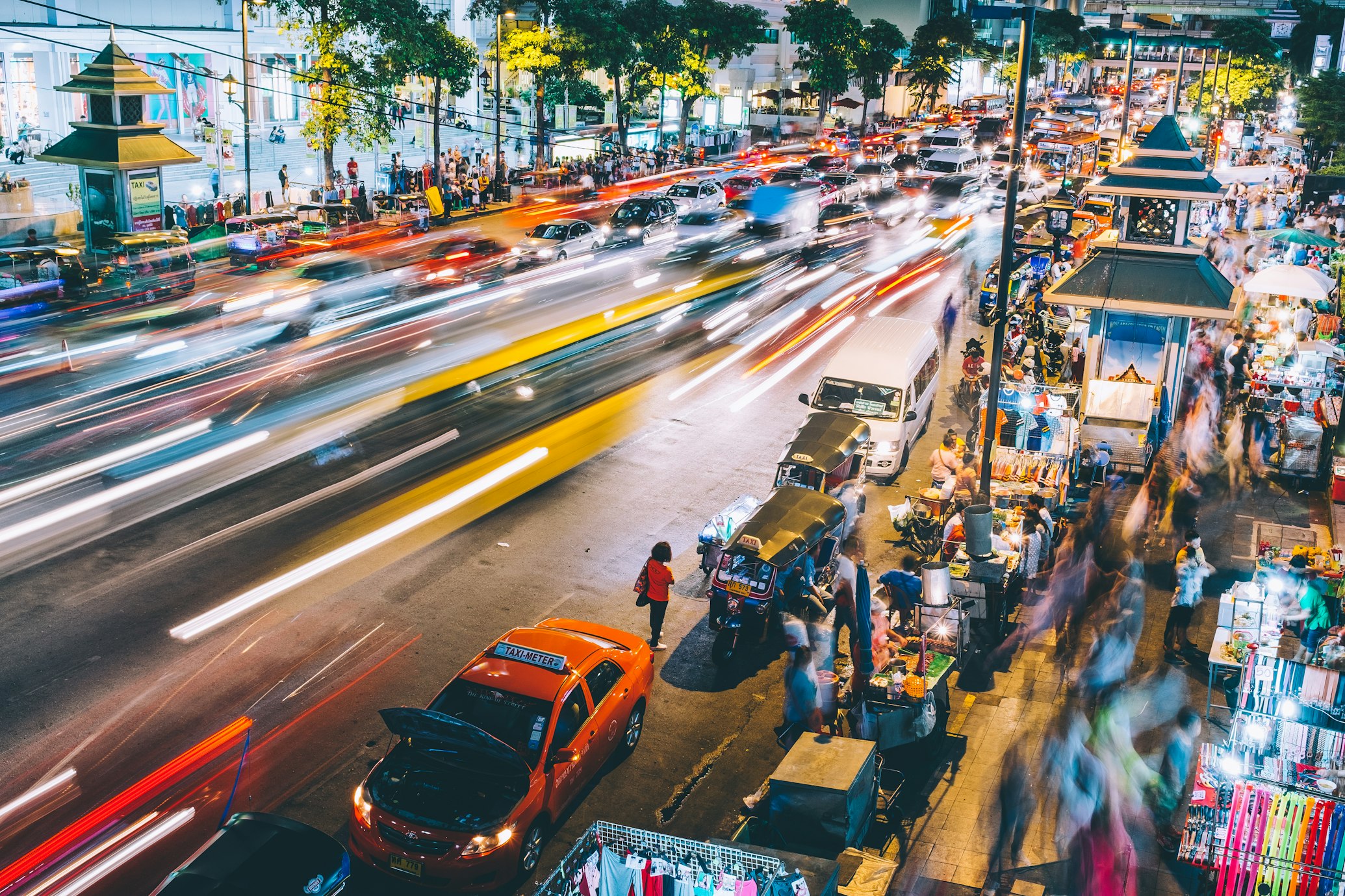 Tipica via trafficata a Bangkok illuminata dalle luci delle macchine