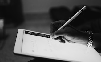 person typing by Apple Pencil on iPad in a room