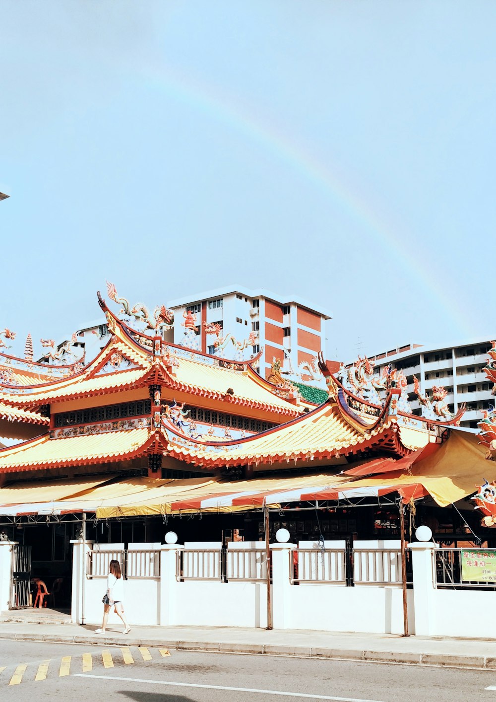 yellow and orange concrete house under rainbow