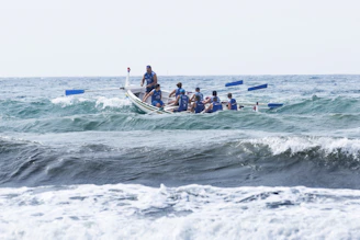 group of men boating on violent waves during daytime