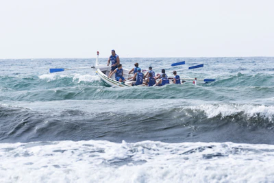 group of men boating on violent waves during daytime