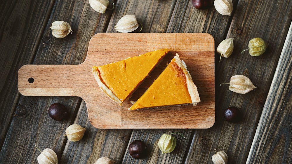 two sliced pies on brown wooden chopping board