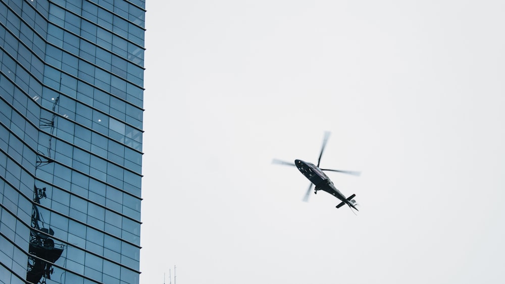 Helicóptero volando cerca de un edificio de gran altura