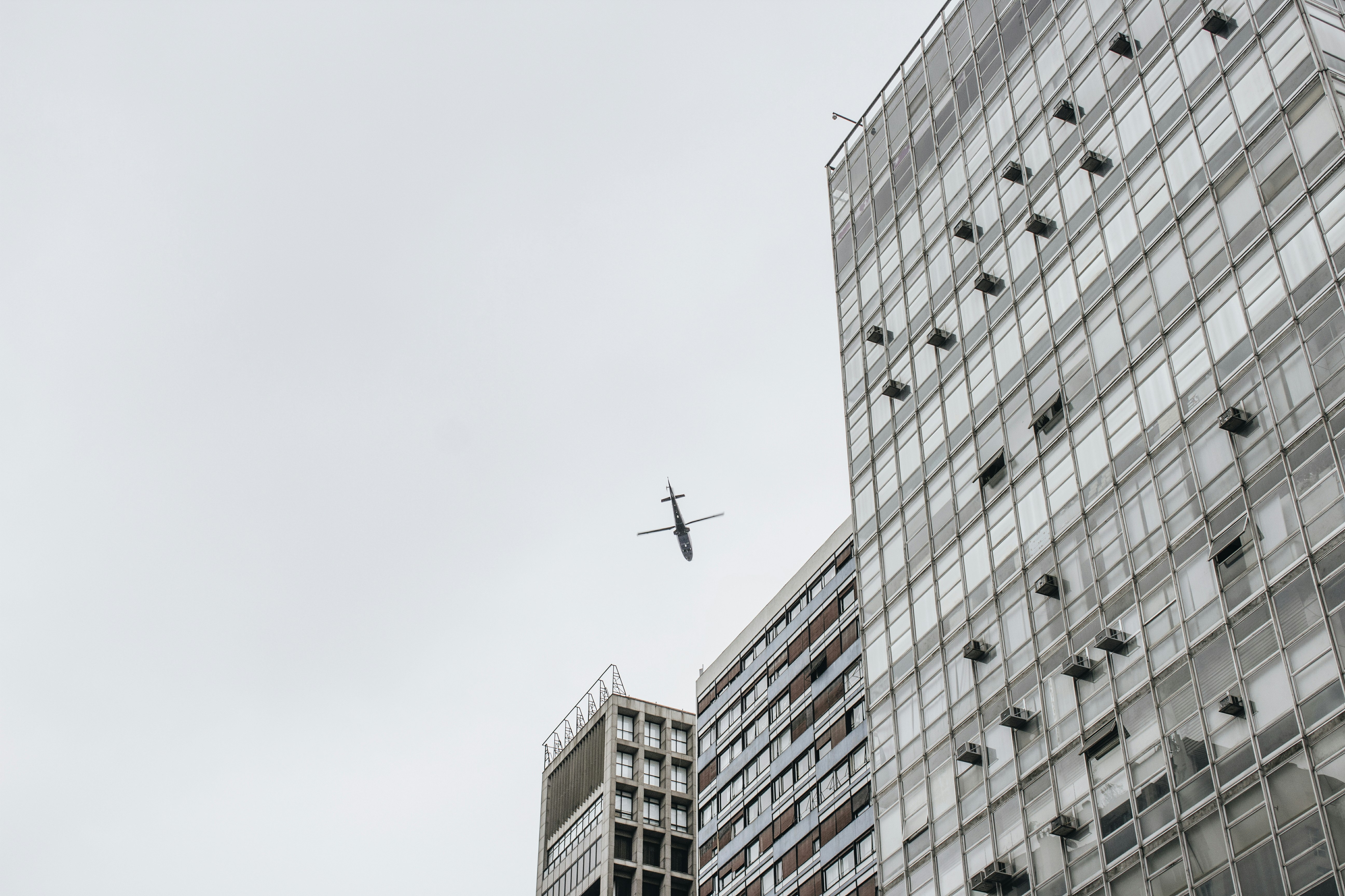 low-angle photography of airliner and high-rise buildings