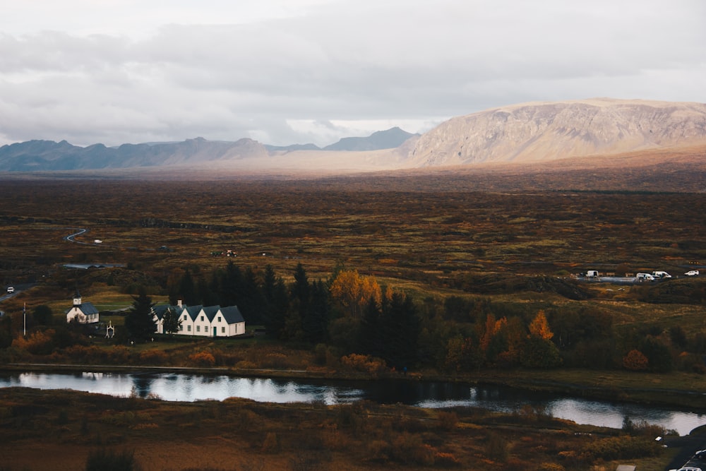 house near lake under white sky during daytime