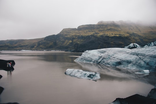 body of water near brown mountain in Mýrdalsjökull Iceland