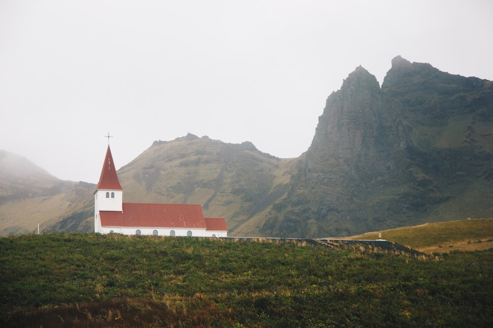 Igreja vermelha e branca perto da montanha