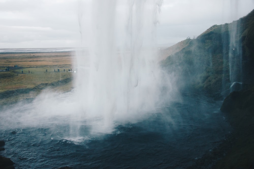 Wasserfall in der Nähe des Berges mit Höhlen-Screenshot